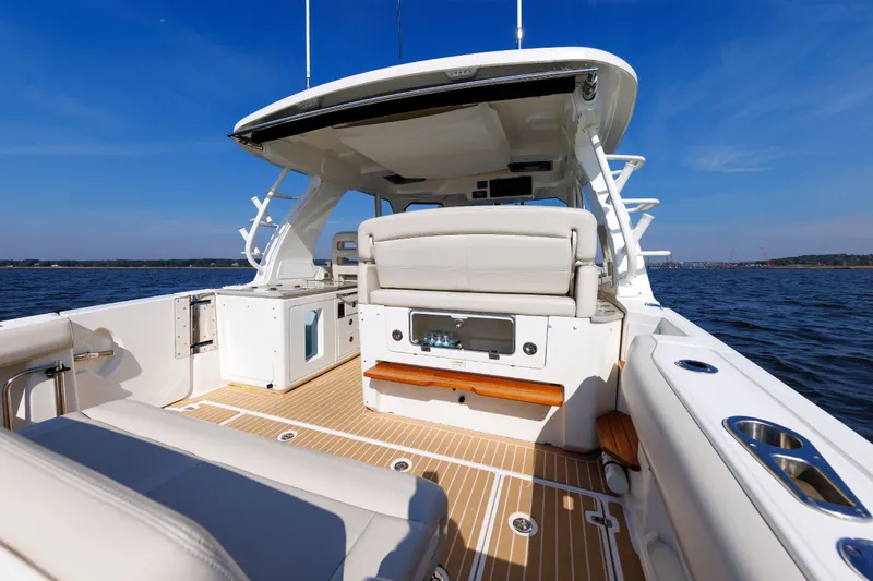 Slide: The Image of 2020 Boston Whaler 380 Realm boat interior with seating, ocean view, and clear blue sky. - 39