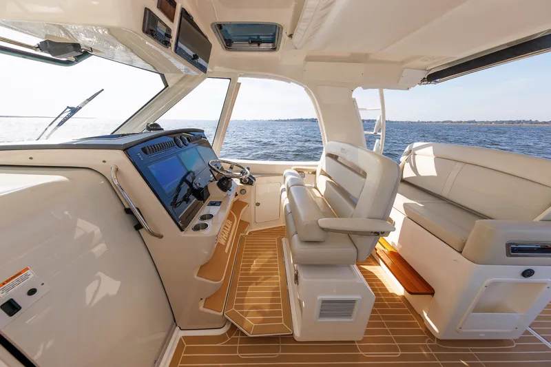 Slide: The Image of 2020 Boston Whaler 380 Realm interior with helm, seating, and ocean view. - 50