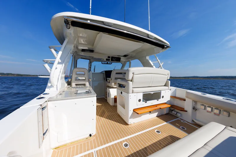 Slide: The Image of 2020 Boston Whaler 380 Realm boat interior with seating, ocean view, and clear blue sky. - 38