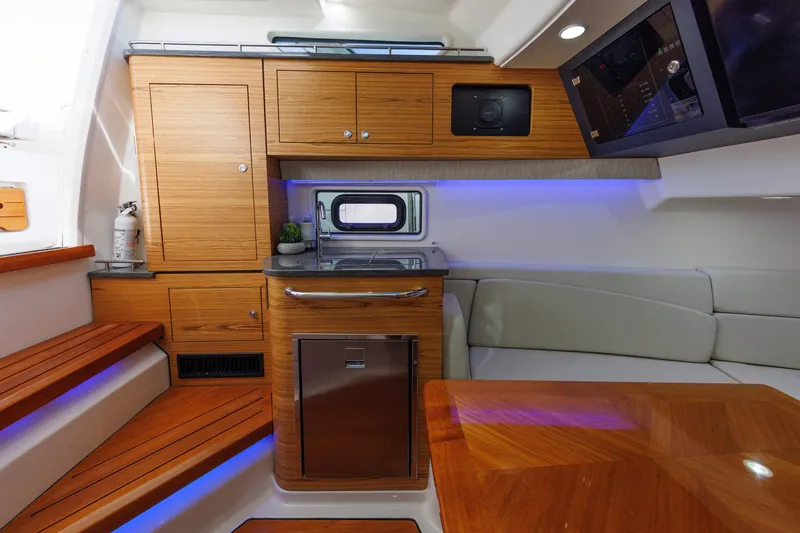 Slide: The Image of 2020 Boston Whaler 380 Realm interior with wood cabinetry, seating, and modern amenities. - 67