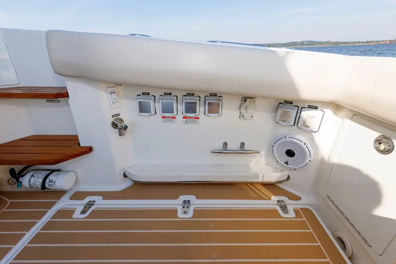 Slide: The Image of 2020 Boston Whaler 380 Realm boat deck with controls and speaker, featuring teak accents. - 37