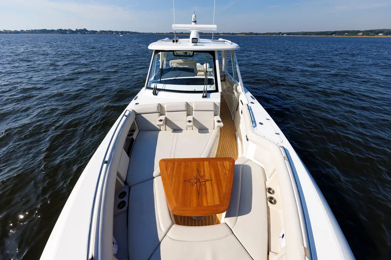 Slide: The Image of 2020 Boston Whaler 380 Realm boat on open water, featuring spacious deck and seating. - 64