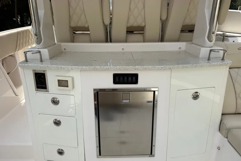 Slide: The Image of 2019 Regal 33 SAV boat interior with kitchenette, featuring storage drawers and stainless steel fridge. - 38