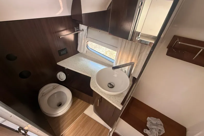 Slide: The Image of Bathroom interior of 2019 Regal 33 SAV boat with modern fixtures and wood accents. - 21