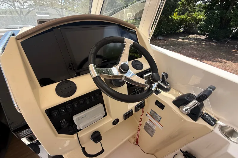 Slide: The Image of Helm of 2019 Regal 33 SAV boat with steering wheel and control panel. - 34