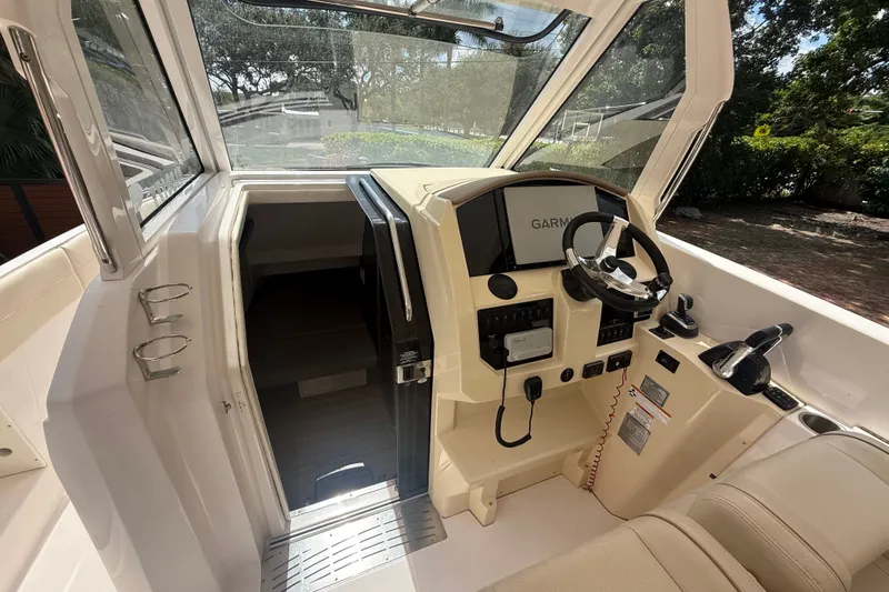 Slide: The Image of 2019 Regal 33 SAV boat cockpit with Garmin navigation system and steering wheel. - 13