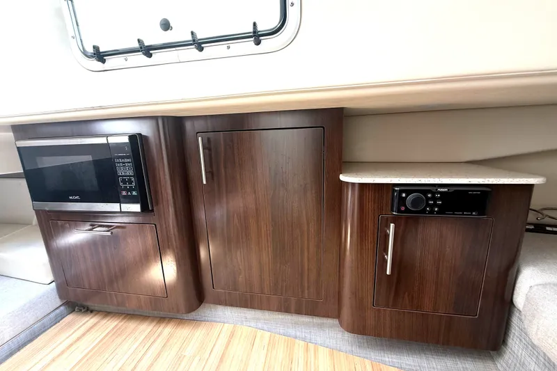 Slide: The Image of Interior of a 2019 Regal 33 SAV with a microwave and wooden cabinets. - 36