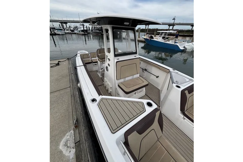 Slide: The Image of 2022 Yamaha Boats 255 FSH Sport E docked, showcasing spacious seating and sleek design. - 11