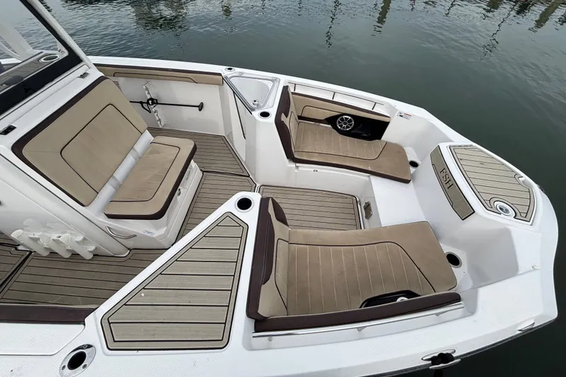 Slide: The Image of 2022 Yamaha Boats 255 FSH Sport E interior with tan seating and sleek design. - 12