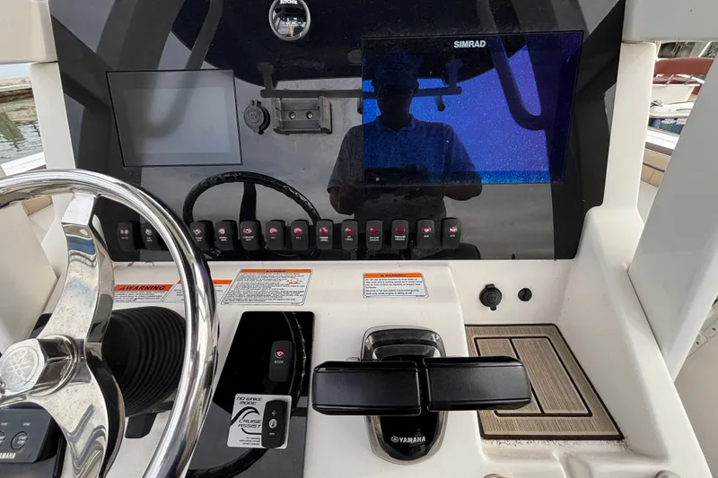Slide: The Image of 2022 Yamaha Boats 255 FSH Sport E dashboard with steering wheel and control panel. - 13