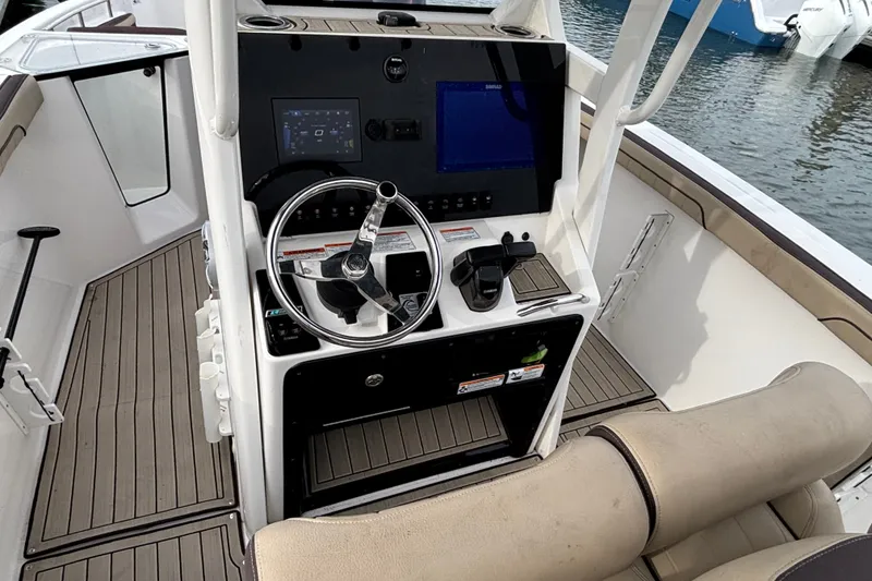 Slide: The Image of 2022 Yamaha Boats 255 FSH Sport E helm with modern controls and steering wheel. - 10