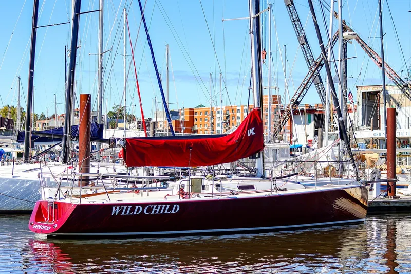 Slide: The Image of 2005 J Boats J/100 sailboat docked, red hull, marina background. - 1