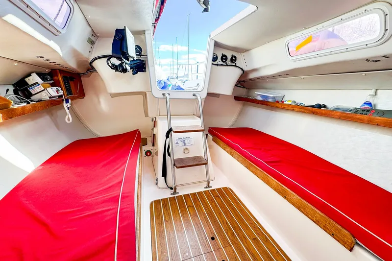 Slide: The Image of Interior of 2005 J Boats J/100 sailboat with red cushions and wooden flooring. - 26