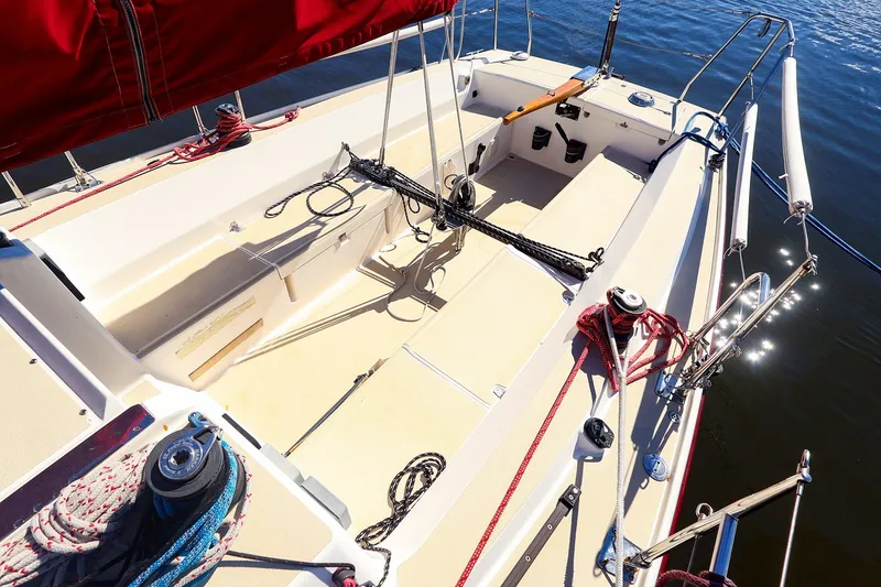 Slide: The Image of 2005 J Boats J/100 sailboat cockpit with red sail, ropes, and winches on calm water. - 11