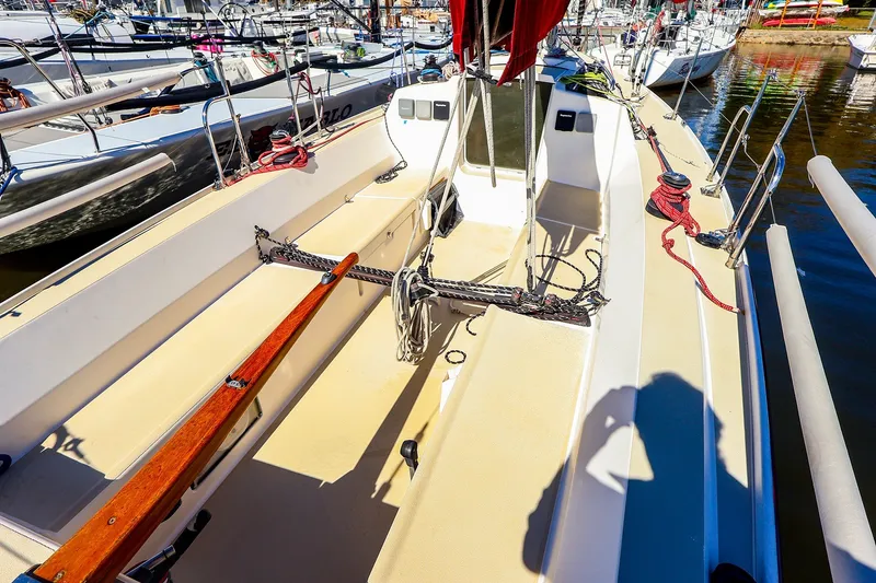 Slide: The Image of 2005 J Boats J/100 sailboat cockpit with ropes and wooden tiller in marina. - 7
