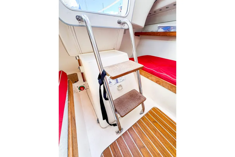 Slide: The Image of Interior of 2005 J Boats J/100 sailboat with wooden steps and red seating. - 24