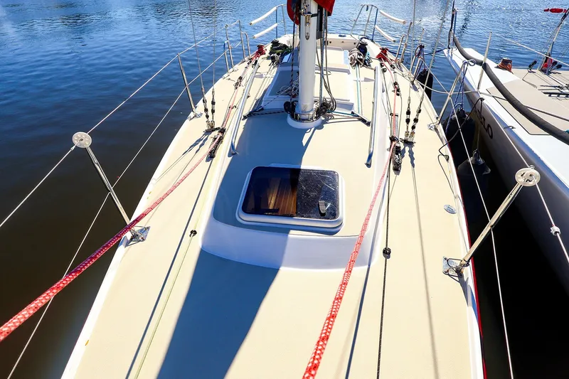 Slide: The Image of 2005 J Boats J/100 sailboat deck with rigging, docked on calm water. - 5
