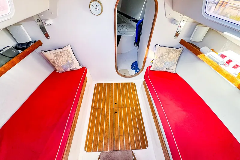 Slide: The Image of Interior of 2005 J Boats J/100 sailboat with red cushions and wooden flooring. - 28