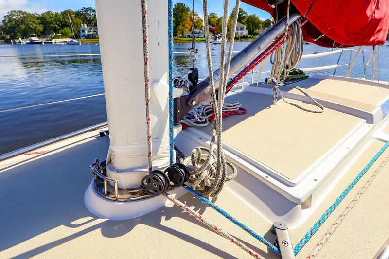 Slide: The Image of 2005 J Boats J/100 sailboat deck with ropes and mast, docked by a serene lake. - 9