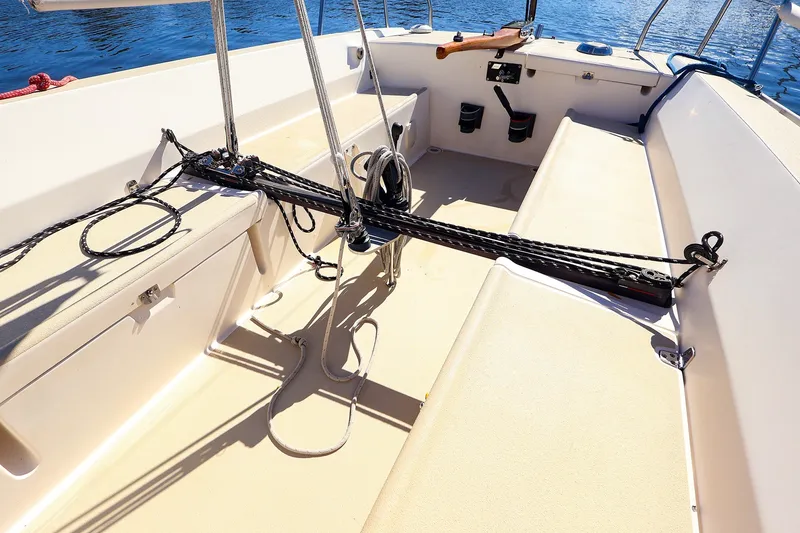 Slide: The Image of Cockpit of 2005 J Boats J/100 sailboat with ropes and seating, on calm water. - 10