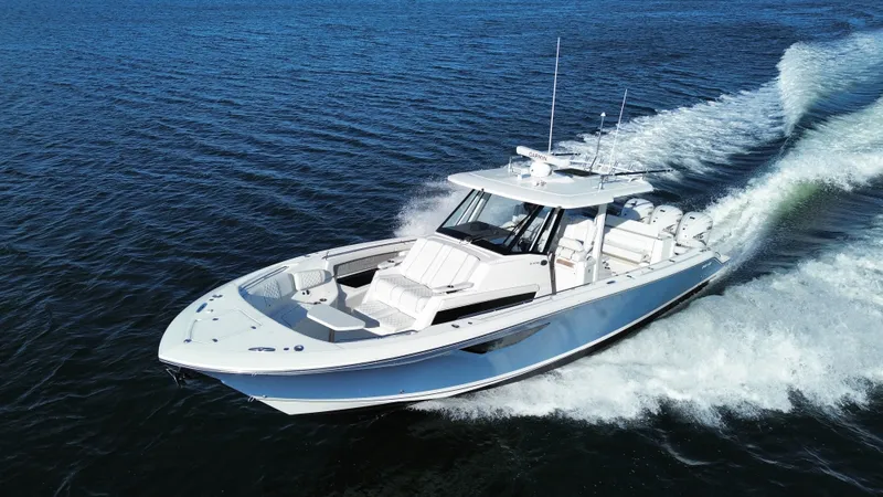 The Image of A white sport boat speeds across the water, leaving a trail of spray behind. - 1