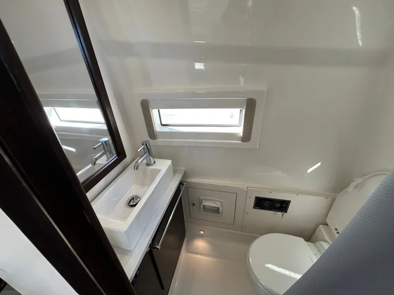 Slide: The Image of Interior view of a modern boat bathroom with sink, toilet, and window. - 22