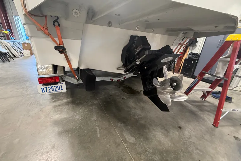 Slide: The Image of 2018 Rinker MTX 22 CC boat on trailer, showing propeller and license plate in garage. - 4