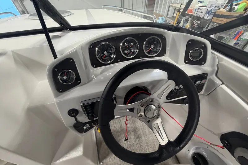 Slide: The Image of 2018 Rinker MTX 22 CC boat dashboard with steering wheel and instrument gauges. - 11