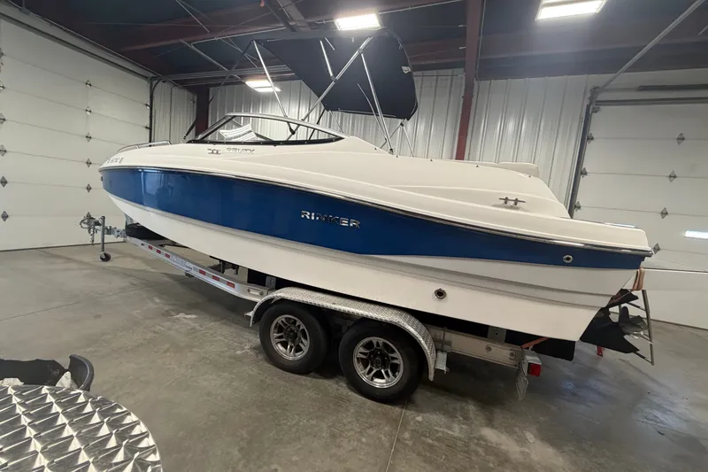 Slide: The Image of 2018 Rinker MTX 22 CC boat on trailer in indoor storage facility. - 2
