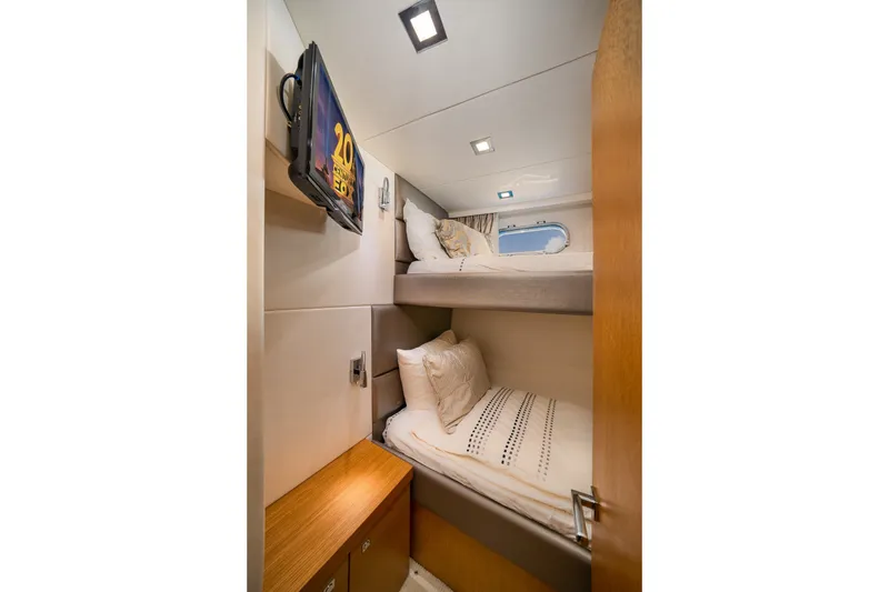 Slide: The Image of Bunk beds in 2012 Sunseeker Manhattan 63 yacht cabin with TV and porthole window. - 20