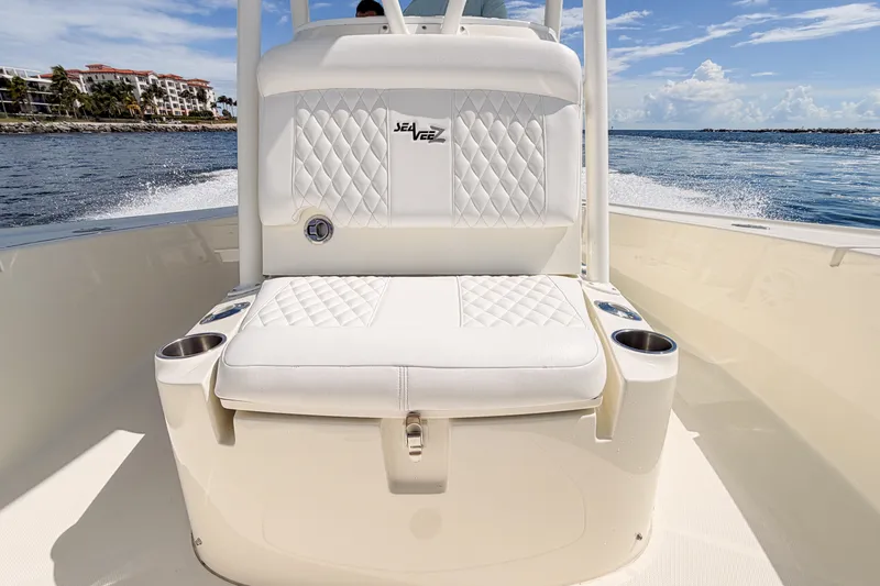Slide: The Image of 2016 SeaVee 270Z boat interior with white cushioned seating and cup holders on a sunny day. - 22