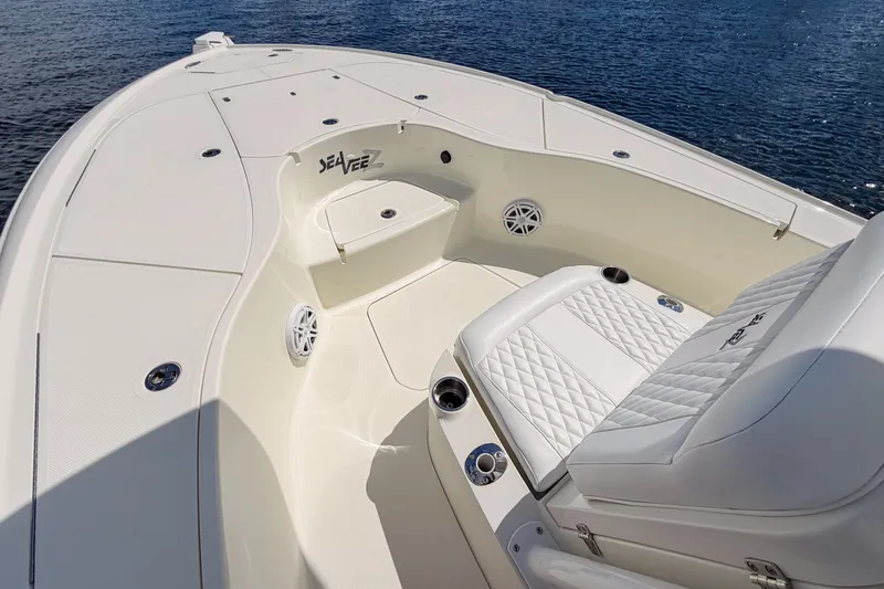 Slide: The Image of 2016 SeaVee 270Z boat interior with white seating and deck, on calm water. - 35