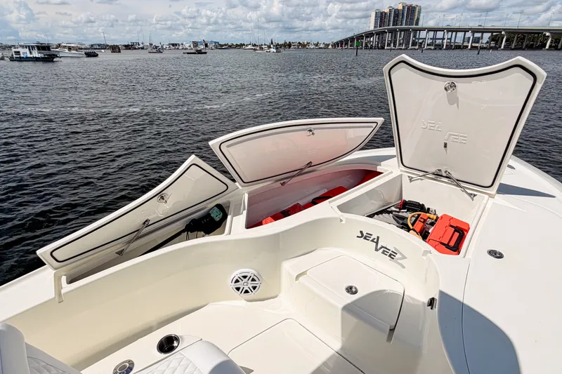 Slide: The Image of 2016 SeaVee 270Z boat with open storage compartments on a calm waterfront. - 26
