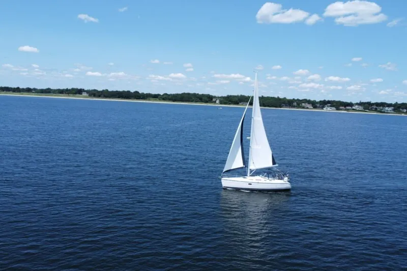 Slide: The Image of Sailboat Hunter 36 (2004) cruising on a serene blue lake under a clear sky. - 18