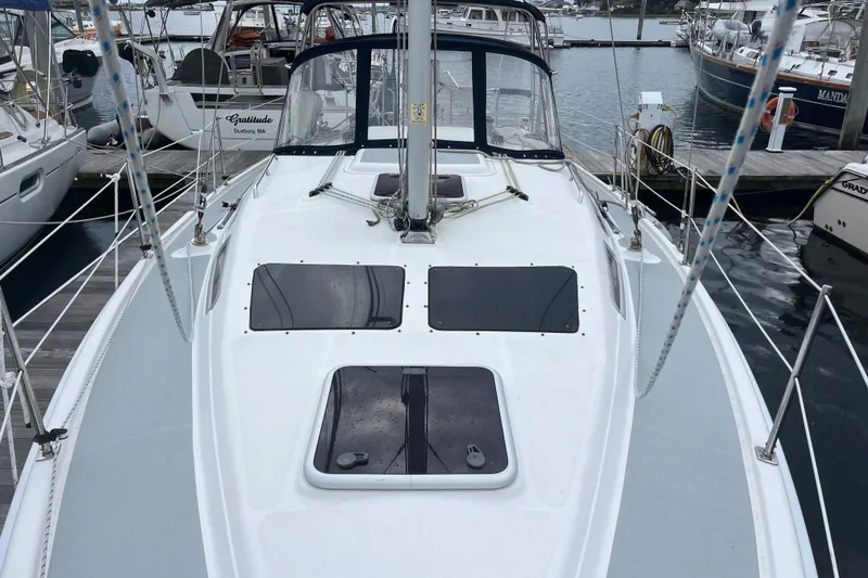 Slide: The Image of 2004 Hunter 36 sailboat docked at marina, showcasing deck and cabin features. - 5