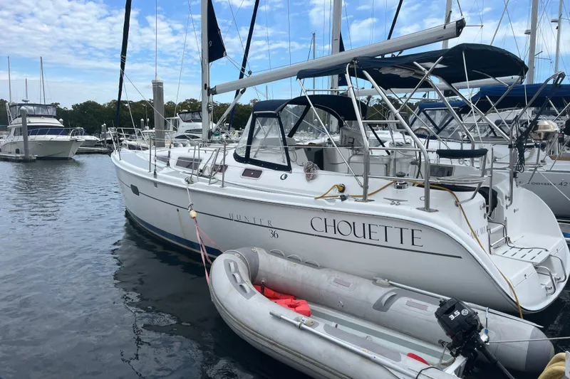 Slide: The Image of Sailboat "Chouette," Hunter 36, 2004 model, docked with inflatable dinghy nearby. - 1