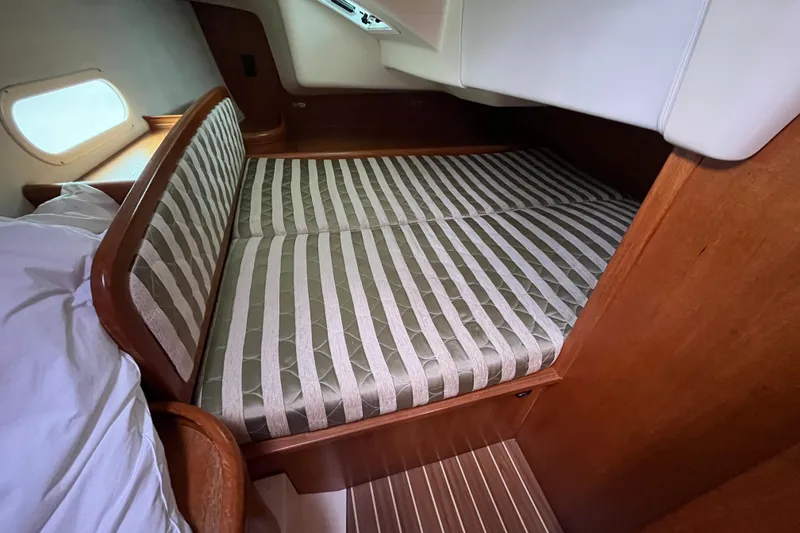 Slide: The Image of Cozy cabin interior of 2004 Hunter 36 sailboat with striped bedding and wooden accents. - 10
