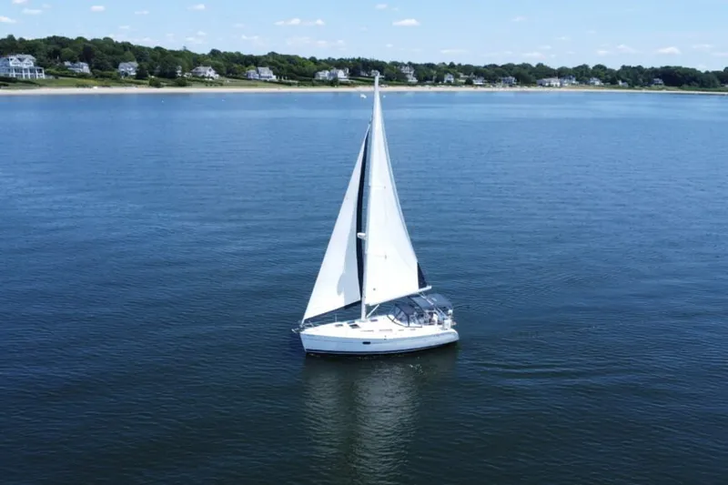 Slide: The Image of Sailboat Hunter 36 (2004) cruising on calm waters near a scenic shoreline. - 13
