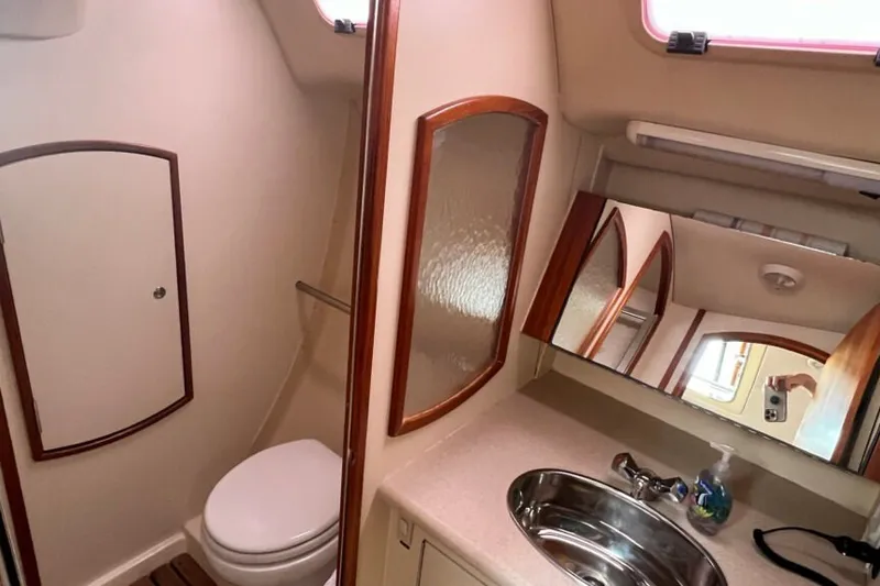 Slide: The Image of Interior of 2004 Hunter 36 sailboat bathroom with sink, mirror, and toilet. - 12