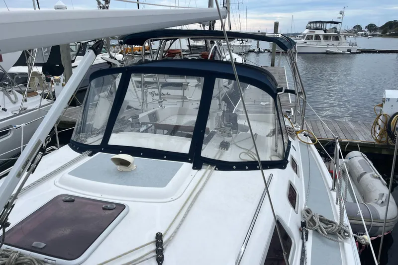 Slide: The Image of 2004 Hunter 36 sailboat docked at marina, featuring a blue canopy and clean deck. - 4