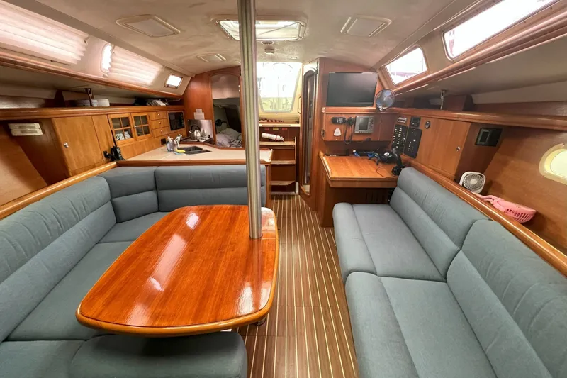 Slide: The Image of Interior of a 2004 Hunter 36 sailboat with wood finishes and cozy seating. - 8