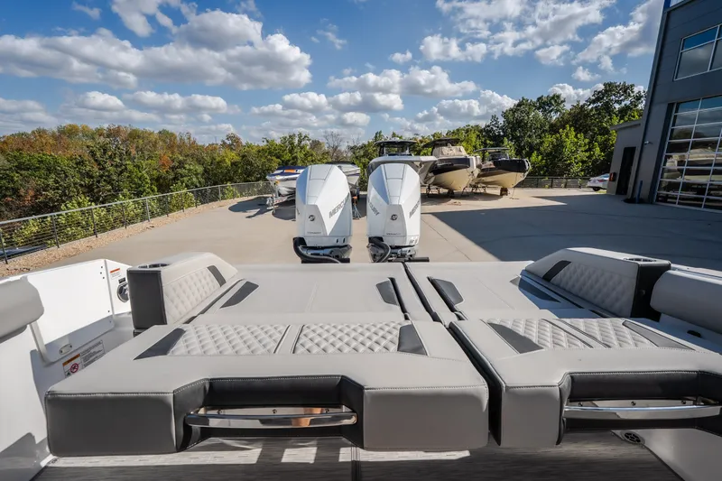 Slide: The Image of 2027 Monterey Elite 27 OB boat with dual Mercury outboard engines, parked outdoors. - 35