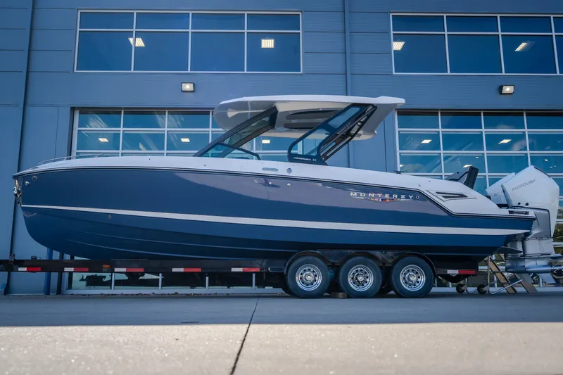 Slide: The Image of 2027 Monterey Elite 27 OB boat on trailer, parked outside modern building. - 72