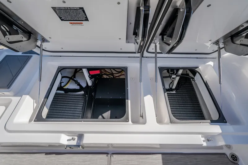 Slide: The Image of Open storage compartments on a 2027 Monterey Elite 27 OB boat deck. - 32