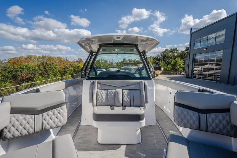 Slide: The Image of 2027 Monterey Elite 27 OB boat interior with luxurious seating and modern design under a blue sky. - 45