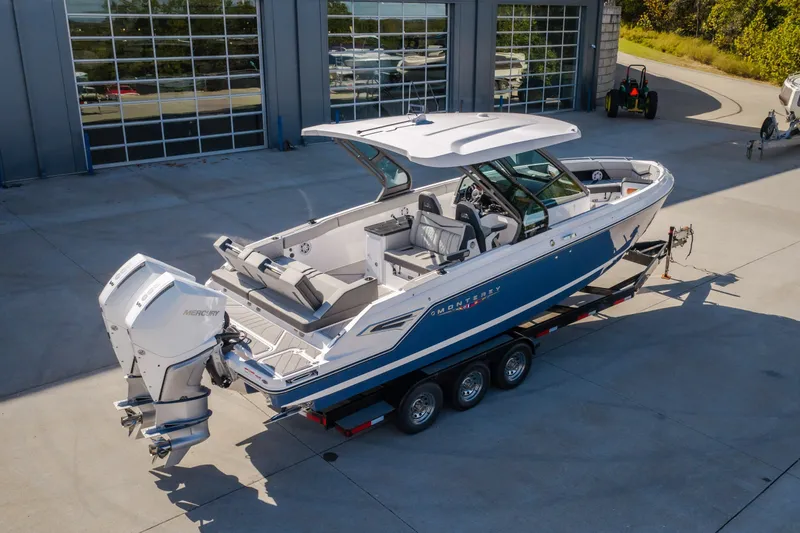 Slide: The Image of 2027 Monterey Elite 27 OB boat on trailer, featuring dual Mercury outboard engines. - 69