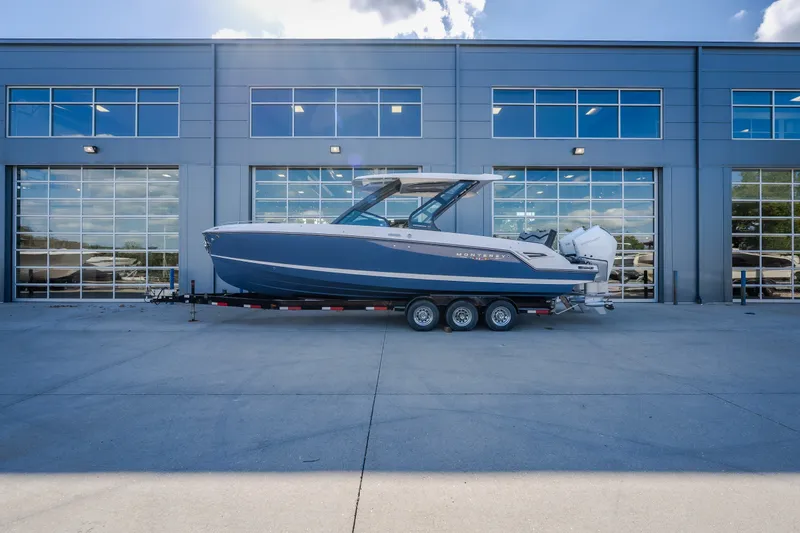 Slide: The Image of 2027 Monterey Elite 27 OB boat on trailer, parked outside modern building. - 71