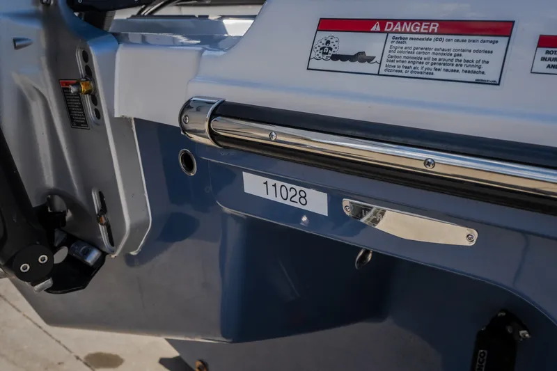 Slide: The Image of Close-up of a 2027 Monterey Elite 27 OB boat's stern with safety warning label. - 73