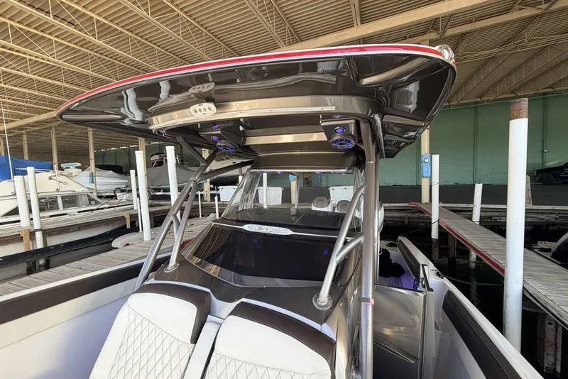 Slide: The Image of 2014 Nor-Tech 340 Sport boat docked in a marina under a covered structure. - 25
