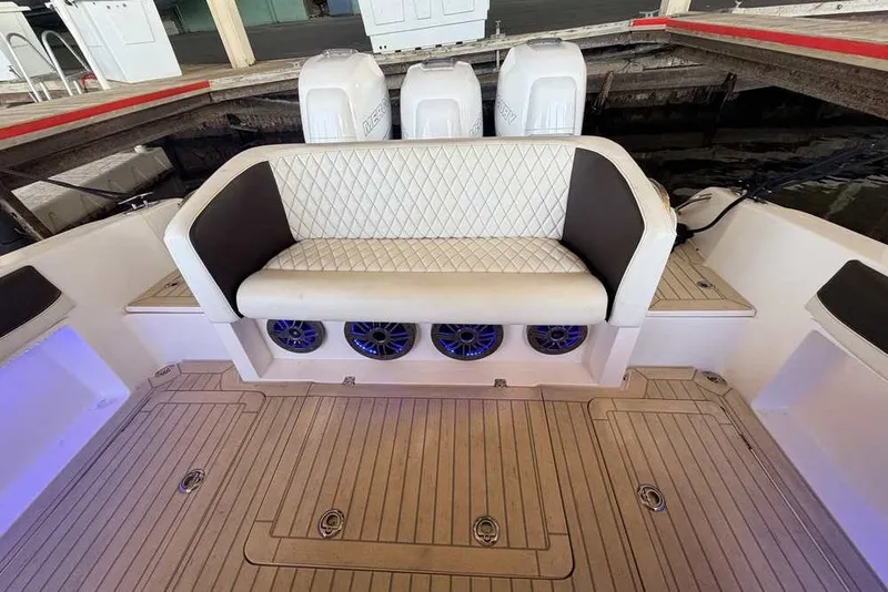Slide: The Image of 2014 Nor-Tech 340 Sport boat interior with cushioned seating and speakers. - 4